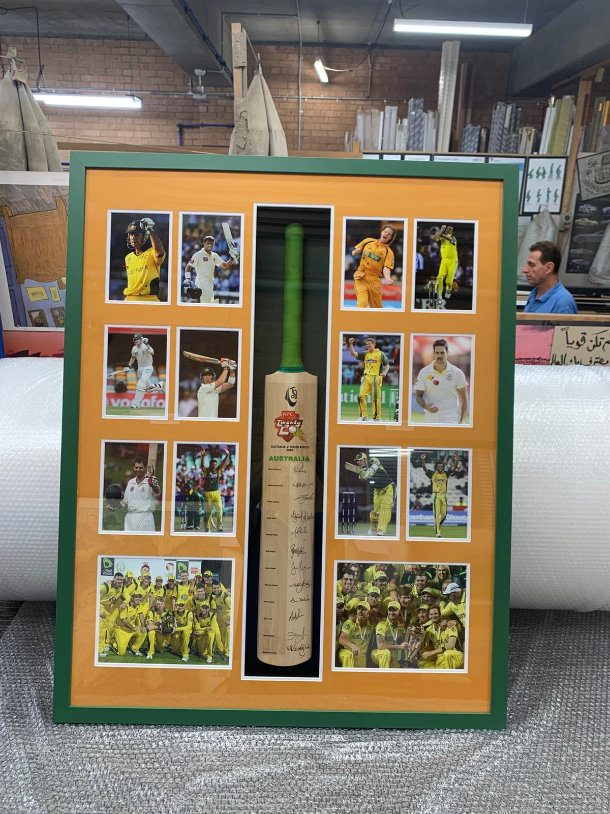 Signed cricket bat framed with action photos and team-coloured matting